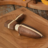 Mader goliath thunderbolt wooden spinning top with starter in a dark wood placed on an oak spinning plate in the Babipur playroom.