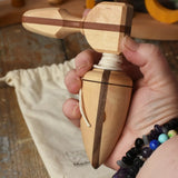 Mader goliath thunderbolt wooden spinning top with starter in an adult's hand in the Babipur playroom.
