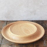 Mader Kreiselmanufaktur 40cm Rondell Ash Wood Spinning Plate placed on a wooden surface in the Babipur playroom.