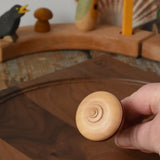 Bottom of the Mader harlekin spinning top in an adult's hand.