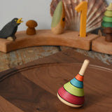 Mader harlekin spinning top placed on a walnut wood spinning plate in the Babipur playroom.
