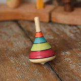 Mader harlekin spinning top placed on a wooden surface in the Babipur playroom.