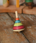 Mader harlekin spinning top placed on a wooden surface in the Babipur playroom.