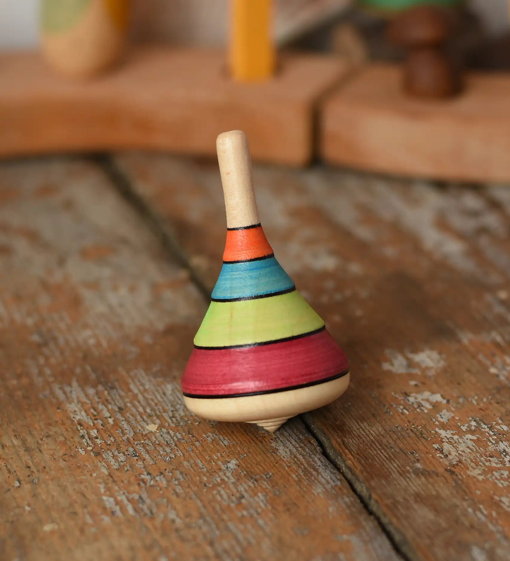 Mader harlekin spinning top placed on a wooden surface in the Babipur playroom.
