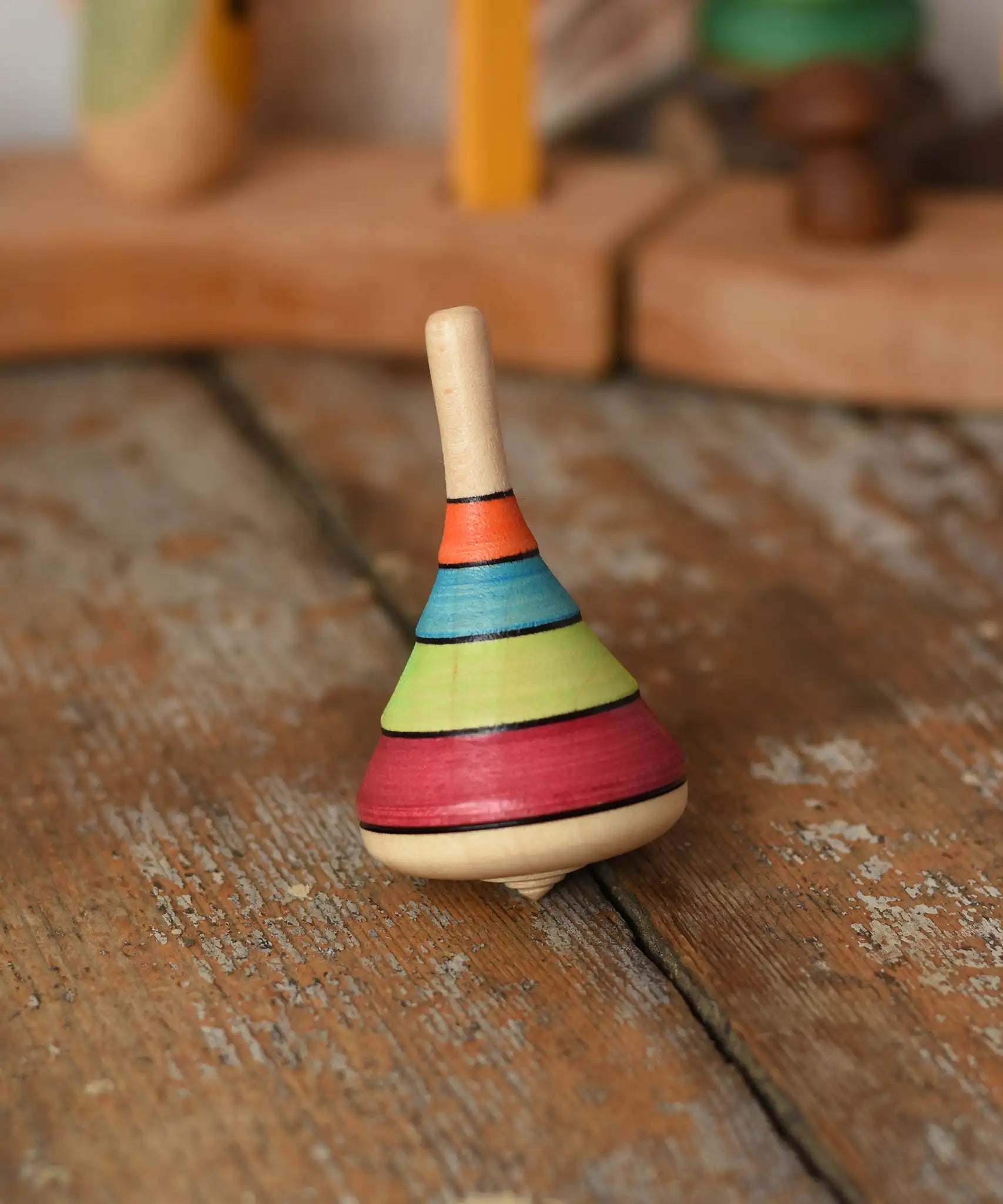 Mader harlekin spinning top placed on a wooden surface in the Babipur playroom.