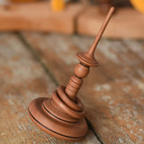 Mader Helene's Captive Rings Apple Spinning Top placed on a wooden desk in the Babipur playroom. 