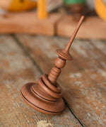 Mader Helene's Captive Rings Apple Spinning Top placed on a wooden desk in the Babipur playroom. 