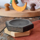 Mader hexagon 8cm spinning top plates in black oak and oak placed on top of each other.