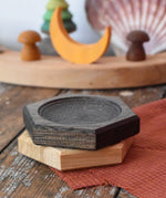 Mader hexagon 8cm spinning top plates in black oak and oak placed on top of each other.