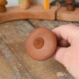 Bottom of the Mader ibis spinning top in an adult's hand.