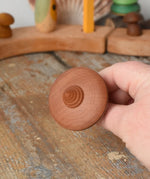 Bottom of the Mader ibis spinning top in an adult's hand.