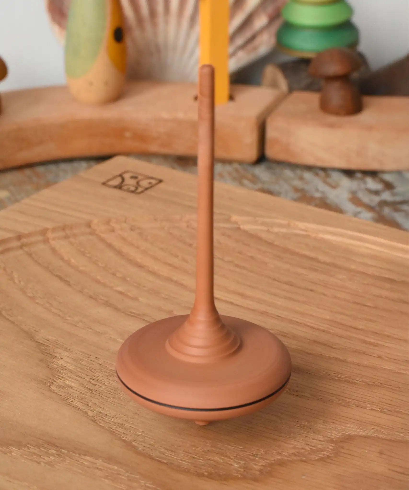 Mader ibis spinning top spinning on an oak spinning plate in the Babipur playroom.