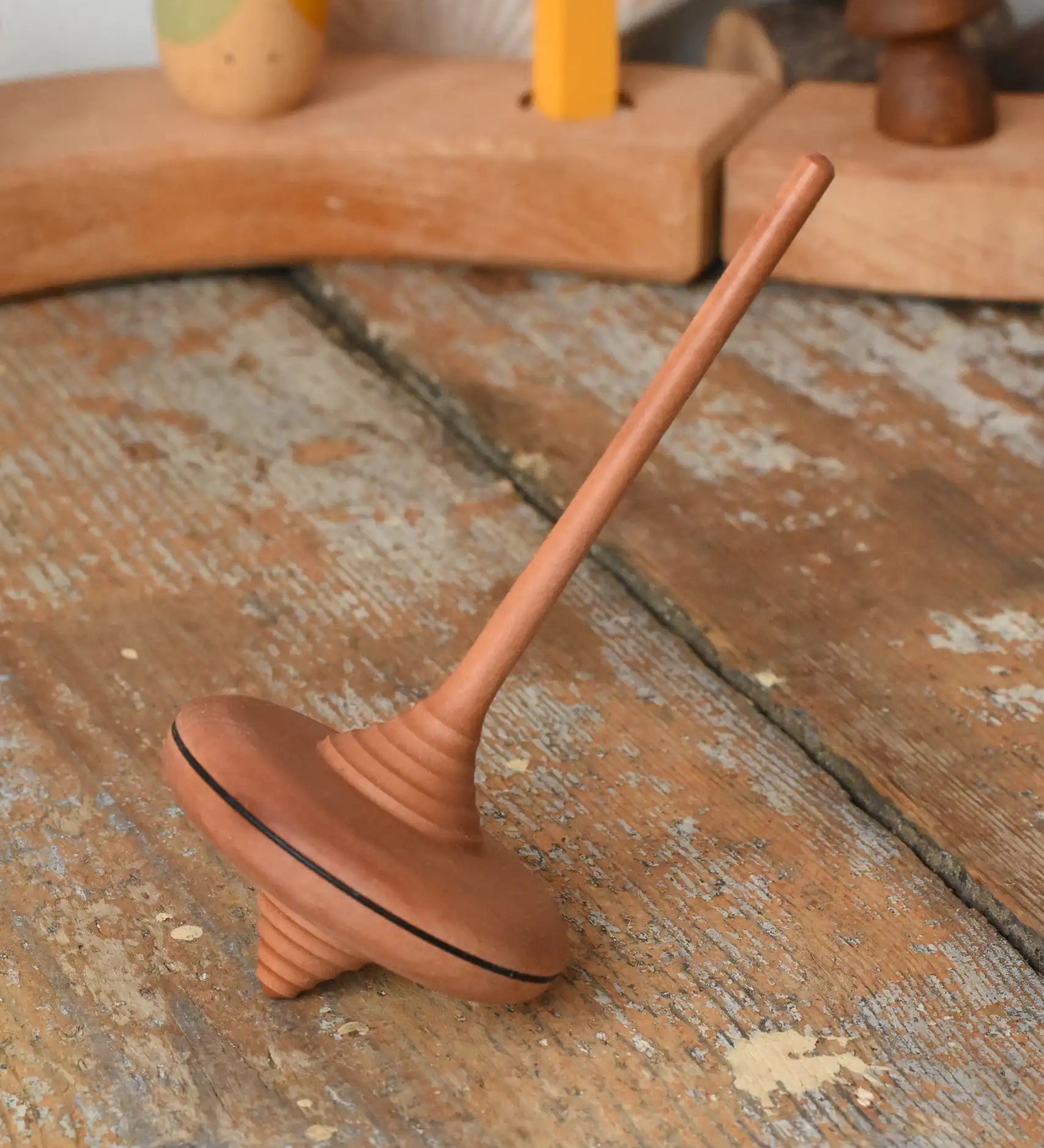 Mader ibis spinning top placed on a wooden desk in the Babipur playroom.