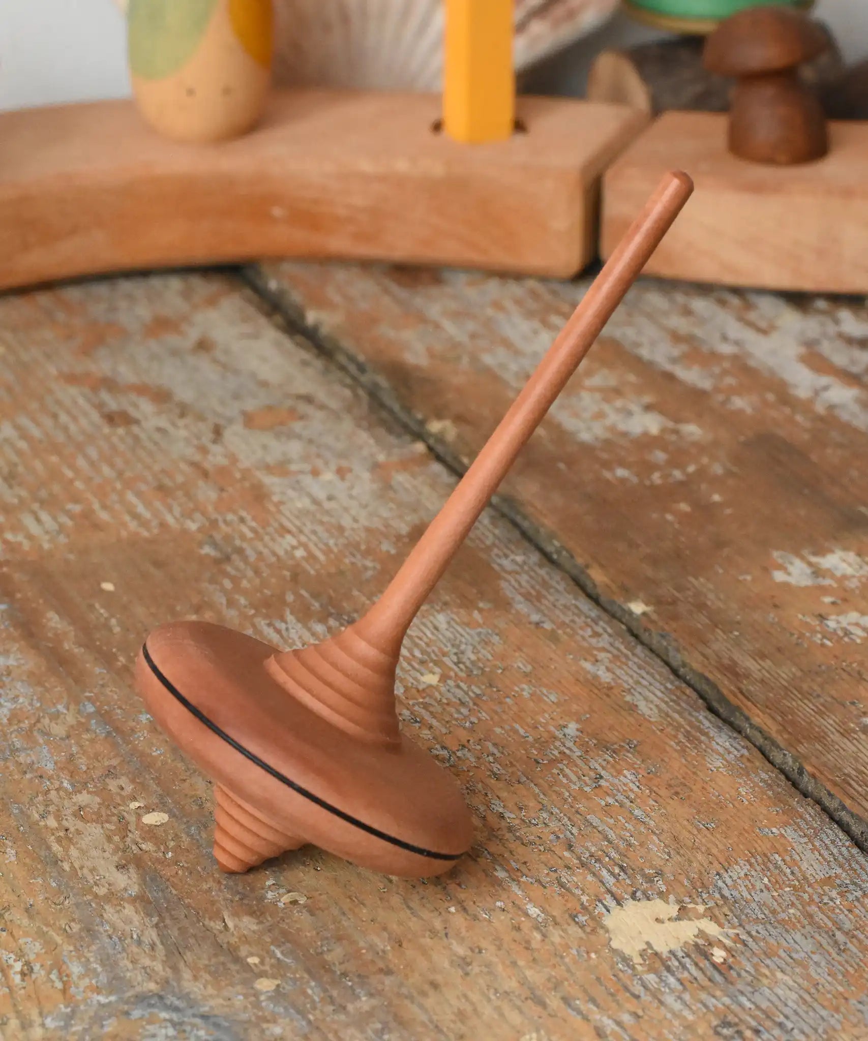 Mader ibis spinning top placed on a wooden desk in the Babipur playroom.