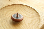 Mader wooden Leporello spinning top spinning on a Mader wooden spinning plate