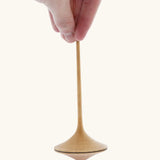 Mader Kreiselmanufaktur 55mm Trumpo Wooden Spinning Top, and adult hand can be seen holding it upright.