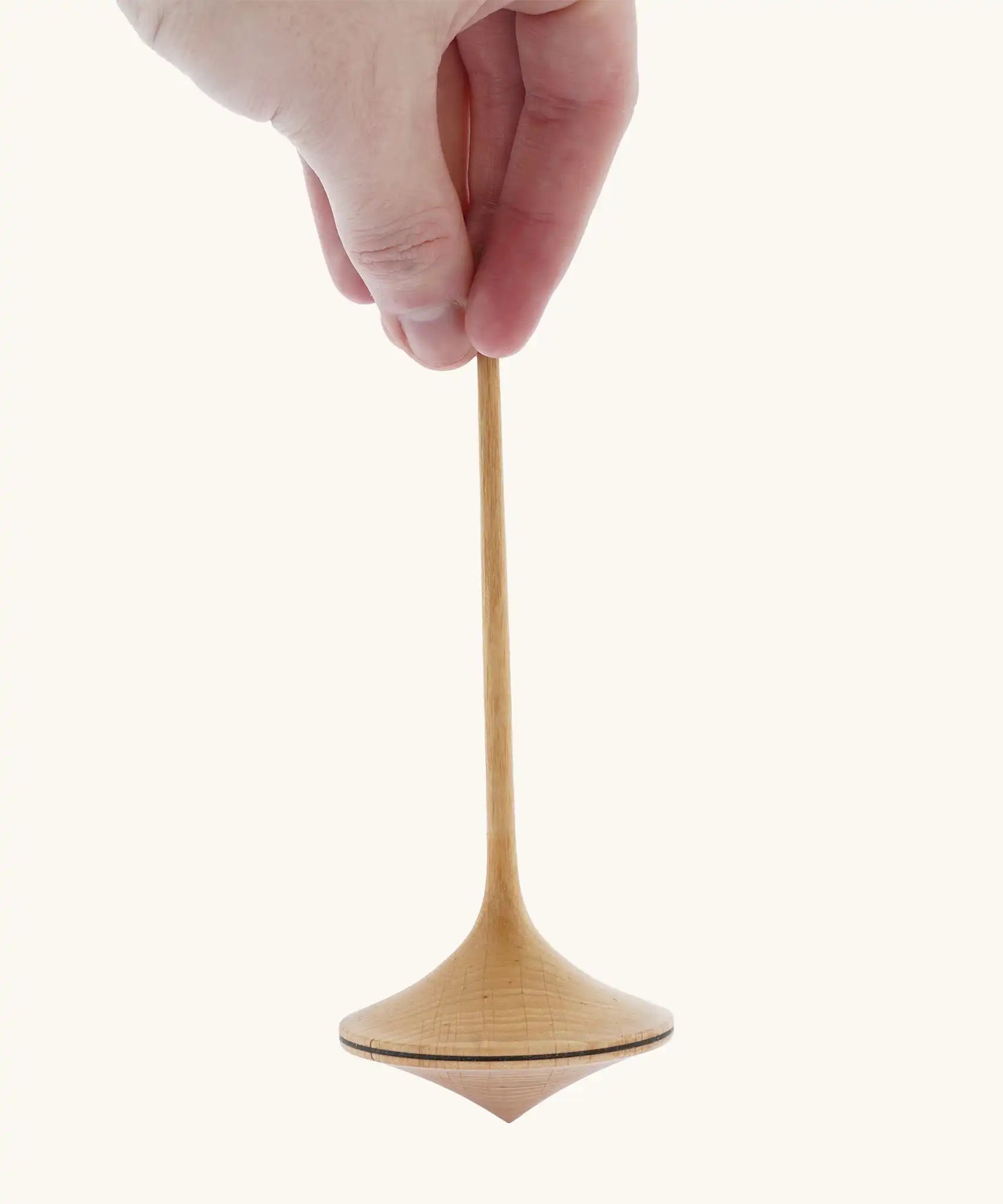 Mader Kreiselmanufaktur 55mm Trumpo Wooden Spinning Top, and adult hand can be seen holding it upright.