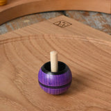Mader Kreiselmanufaktur round ash turn over spinning top toy placed on an oak spinning plate in the Babipur playroom.