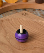 Mader Kreiselmanufaktur round ash turn over spinning top toy placed on an oak spinning plate in the Babipur playroom.