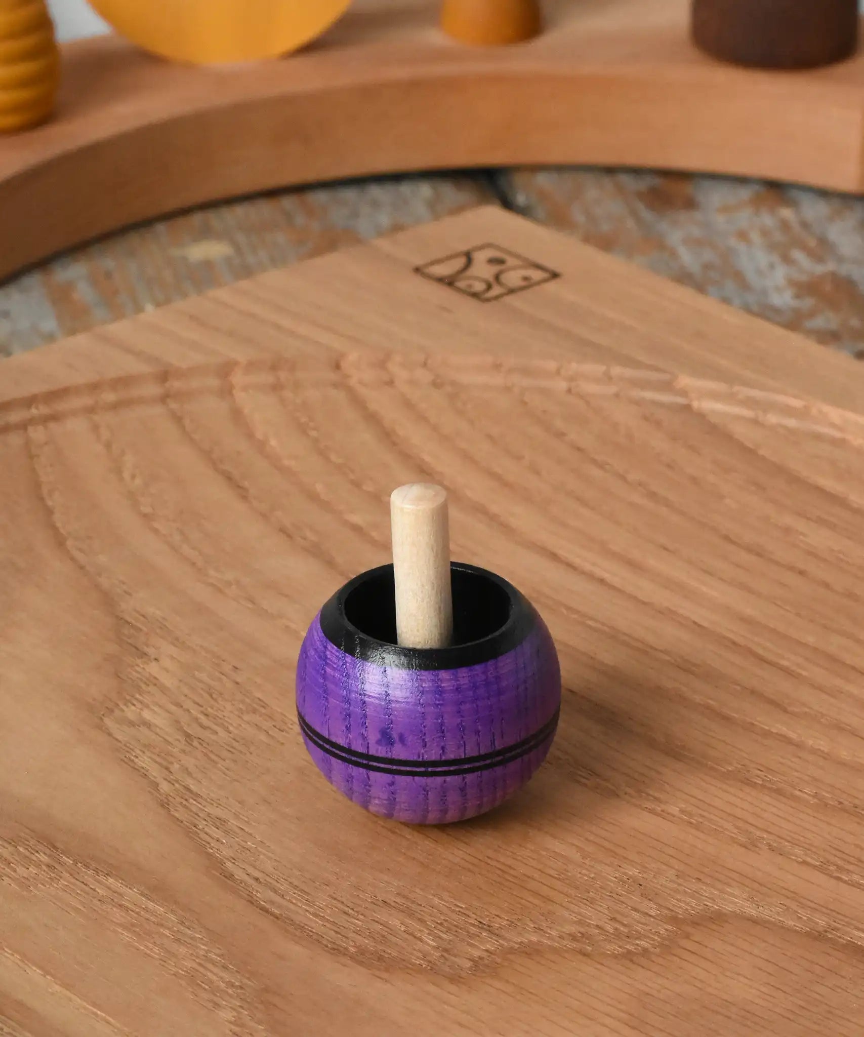 Mader Kreiselmanufaktur round ash turn over spinning top toy placed on an oak spinning plate in the Babipur playroom.