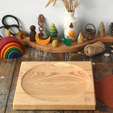 Mader Kreiselmanufaktur Large 25cm ash Spinning Plate placed on a wooden surface in the Babipur playroom.