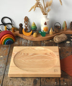 Mader Kreiselmanufaktur Large 25cm ash Spinning Plate placed on a wooden surface in the Babipur playroom.