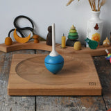 Mader Kreiselmanufaktur 25cm Large Oak Spinning Plate with a blue pull string spinning top spinning on it in the Babipur playroom. 