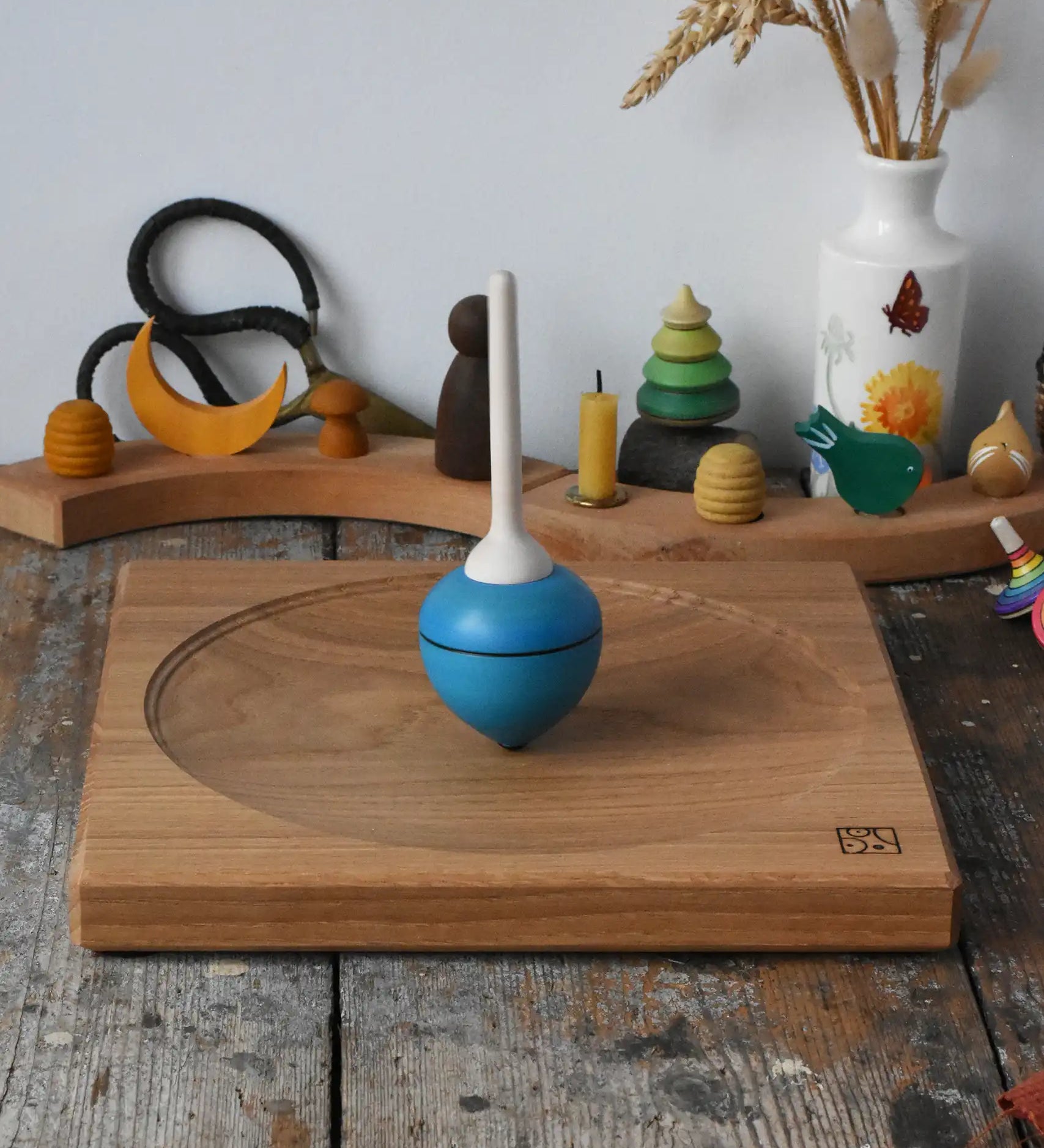 Mader Kreiselmanufaktur 25cm Large Oak Spinning Plate with a blue pull string spinning top spinning on it in the Babipur playroom. 