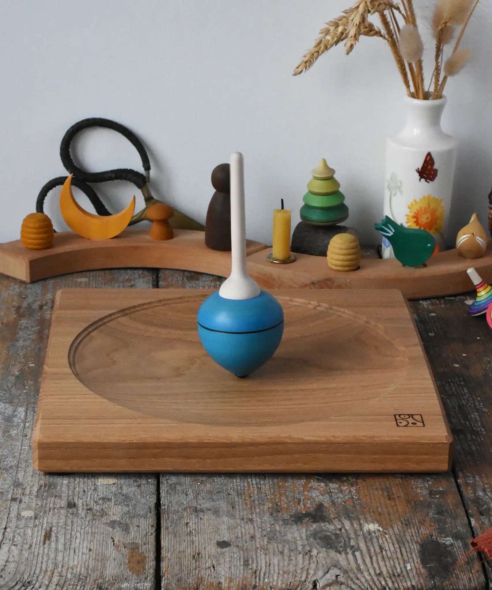 Mader Kreiselmanufaktur 25cm Large Oak Spinning Plate with a blue pull string spinning top spinning on it in the Babipur playroom. 