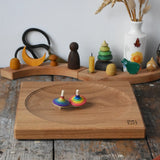 Mader Kreiselmanufaktur 25cm Large Oak Spinning Platewith two rainbow spinning tops in motion in the Babipur playroom. 