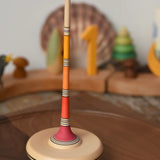 Mader Kreiselmanufaktur Large Arabella Spinning Top spinning on a walnut wood spinning plate. 
