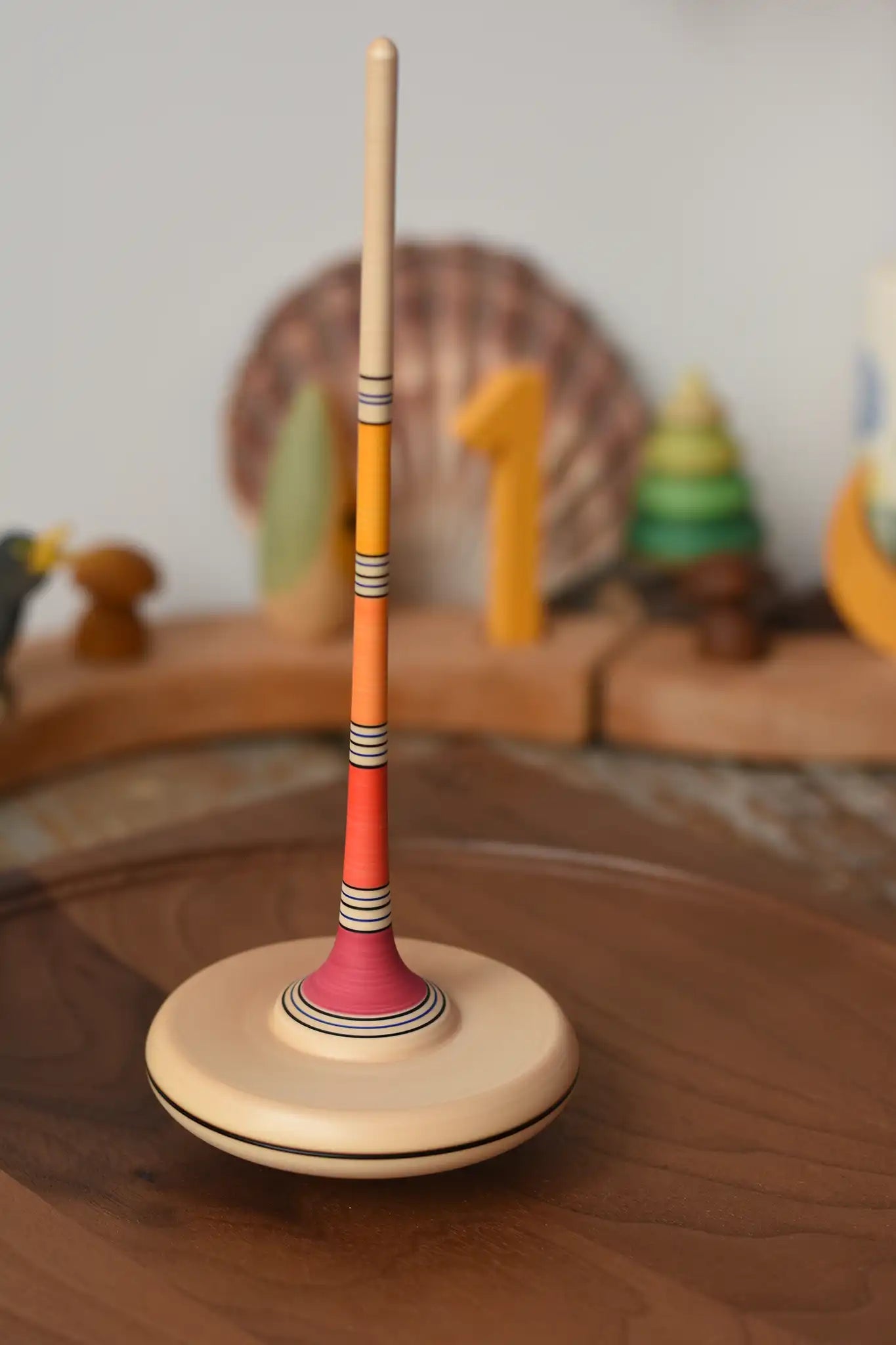 Mader Kreiselmanufaktur Large Arabella Spinning Top spinning on a walnut wood spinning plate. 