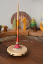 Mader Kreiselmanufaktur Large Arabella Spinning Top spinning on a walnut wood spinning plate. 