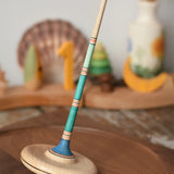 Mader Kreiselmanufaktur Large Arabella Spinning Top placed on a walnut wood spinning plate. 