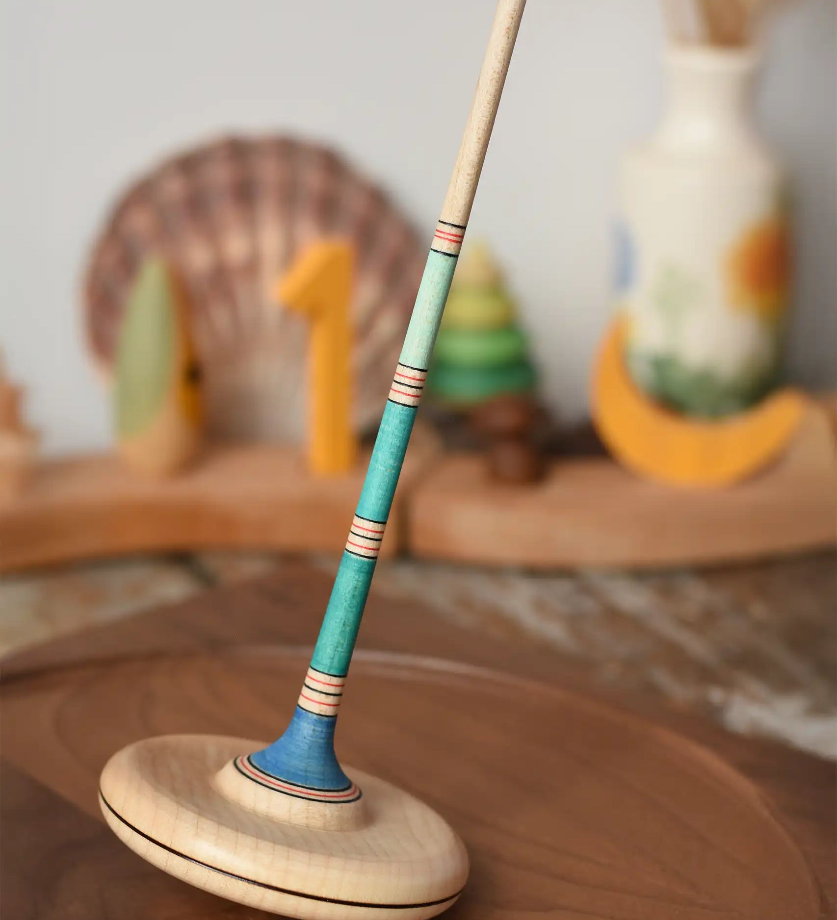 Mader Kreiselmanufaktur Large Arabella Spinning Top placed on a walnut wood spinning plate. 