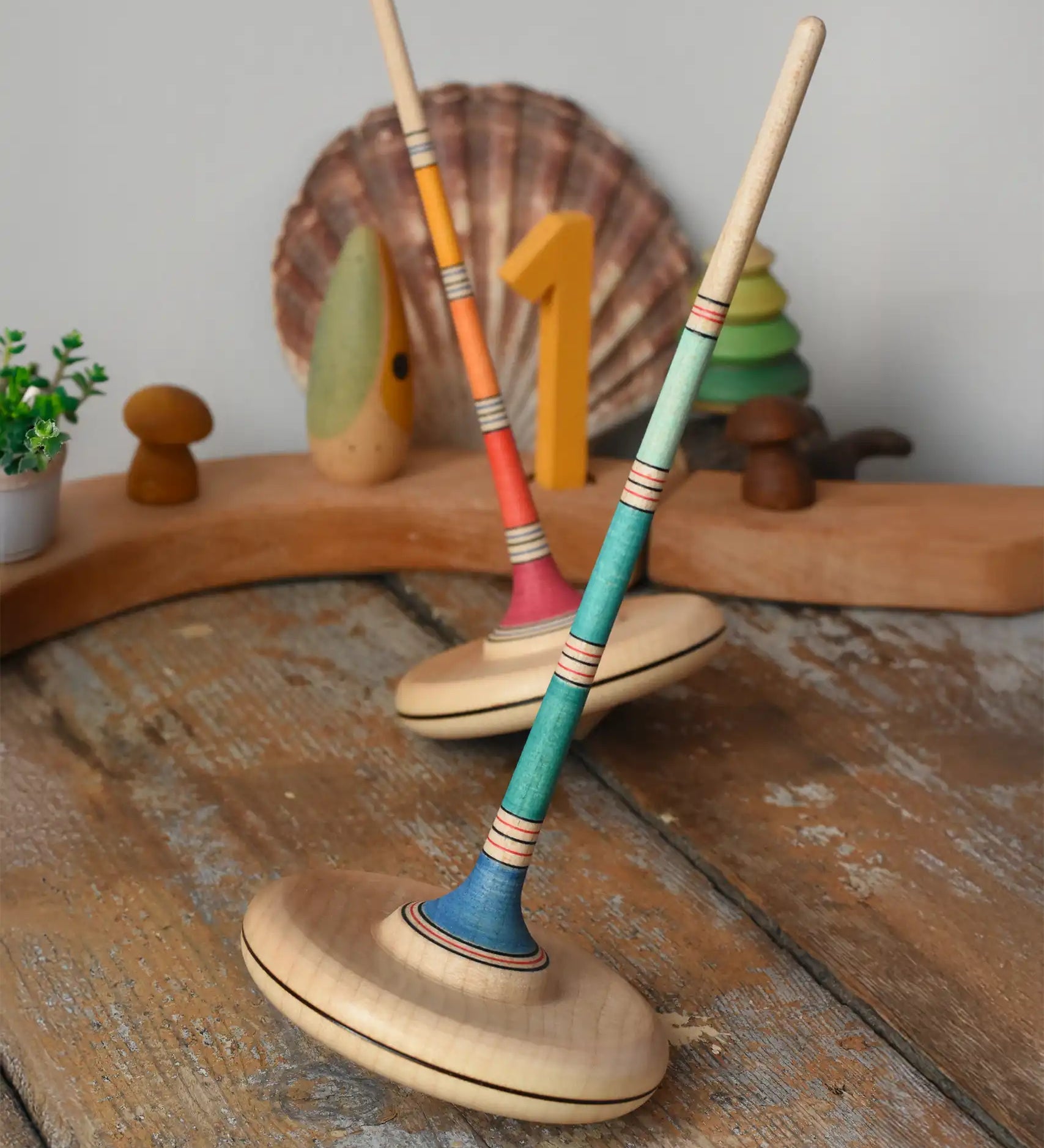 Mader Kreiselmanufaktur Large Arabella Spinning Tops placed on a wooden surface in the Babipur playroom.