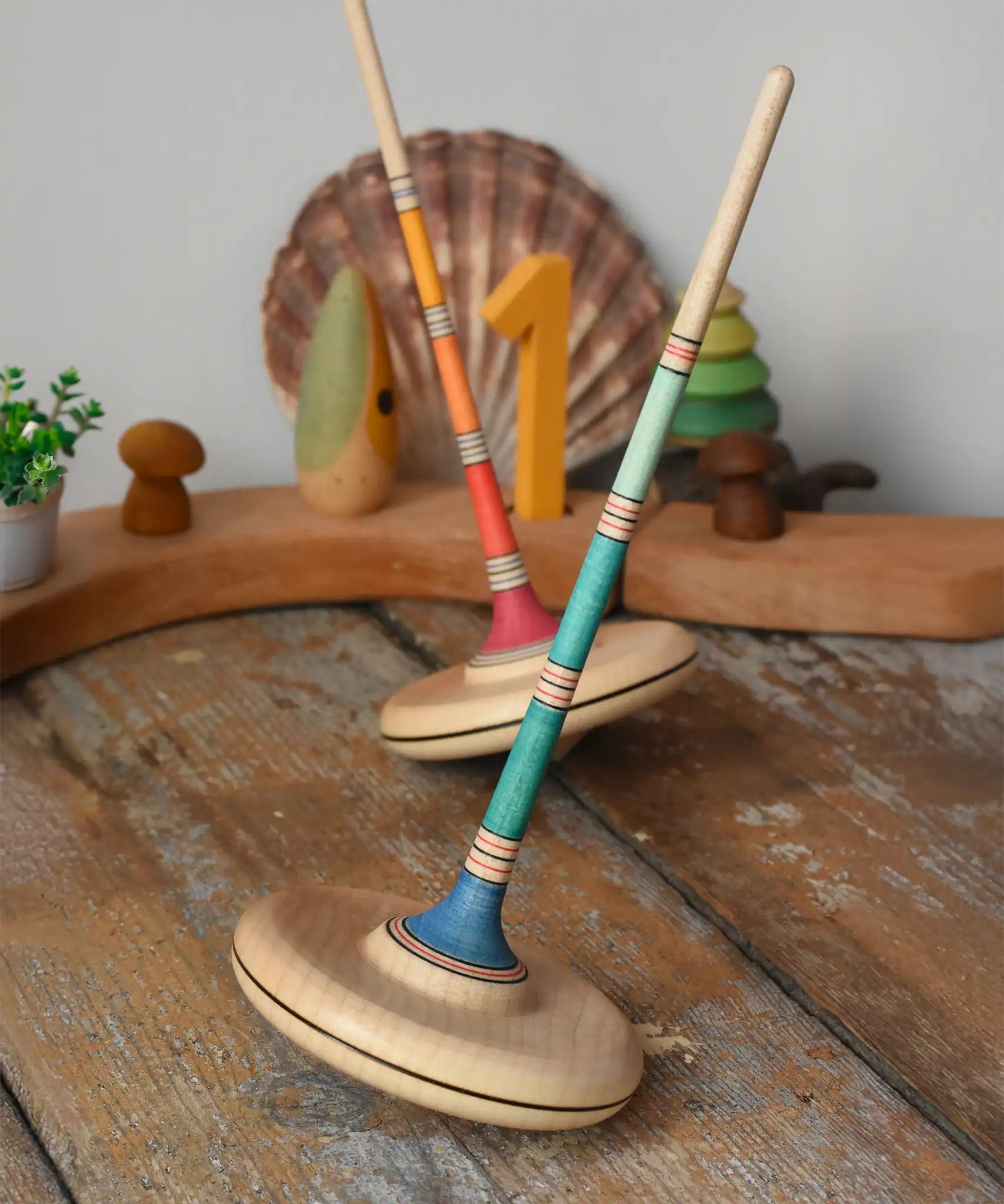 Mader Kreiselmanufaktur Large Arabella Spinning Tops placed on a wooden surface in the Babipur playroom.