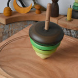 Mader pull-string tree spinning top spinning on a cherry wood spinning plate in the Babipur playroom.