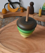 Mader pull-string tree spinning top spinning on a cherry wood spinning plate in the Babipur playroom.