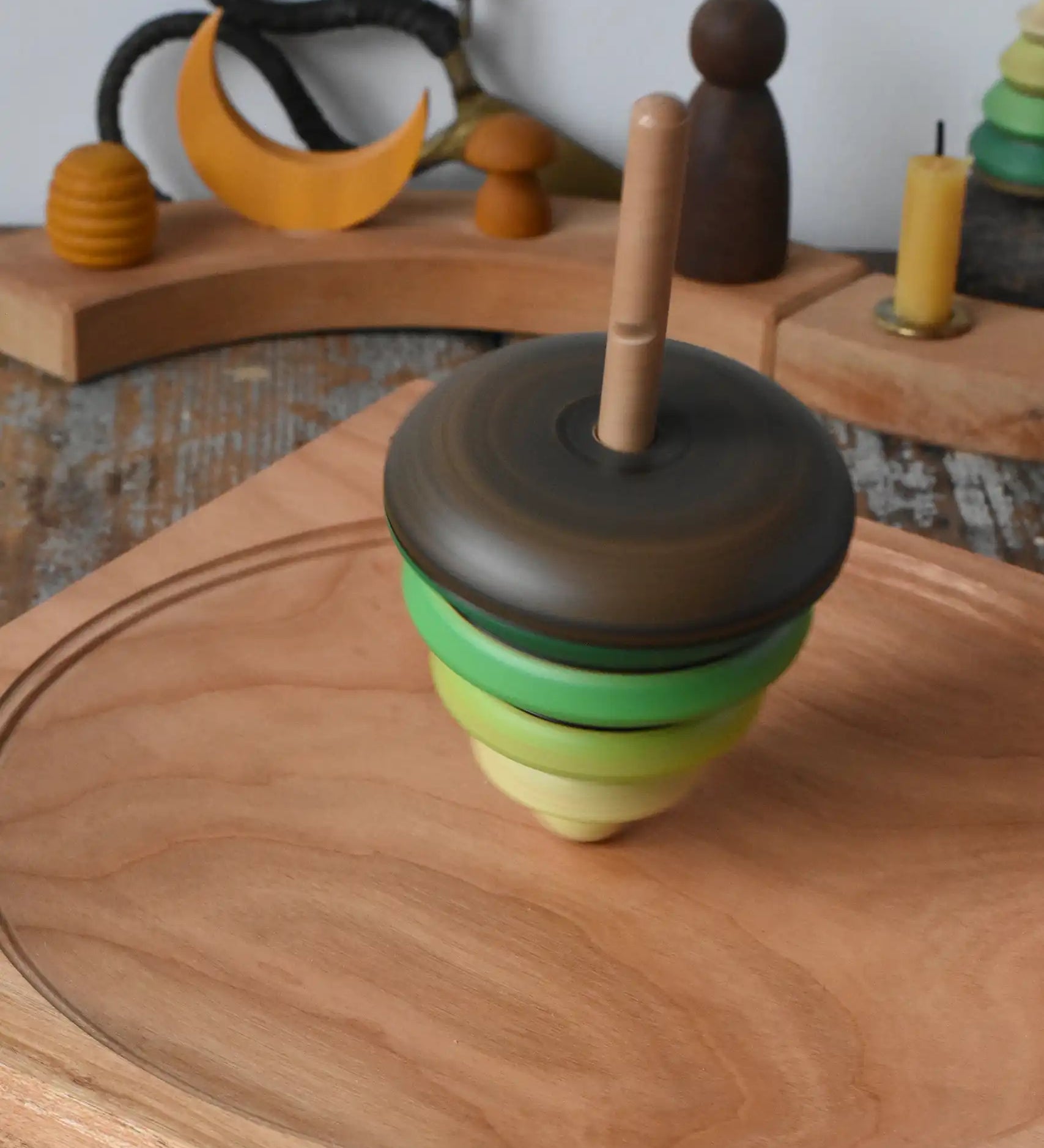 Mader pull-string tree spinning top spinning on a cherry wood spinning plate in the Babipur playroom.