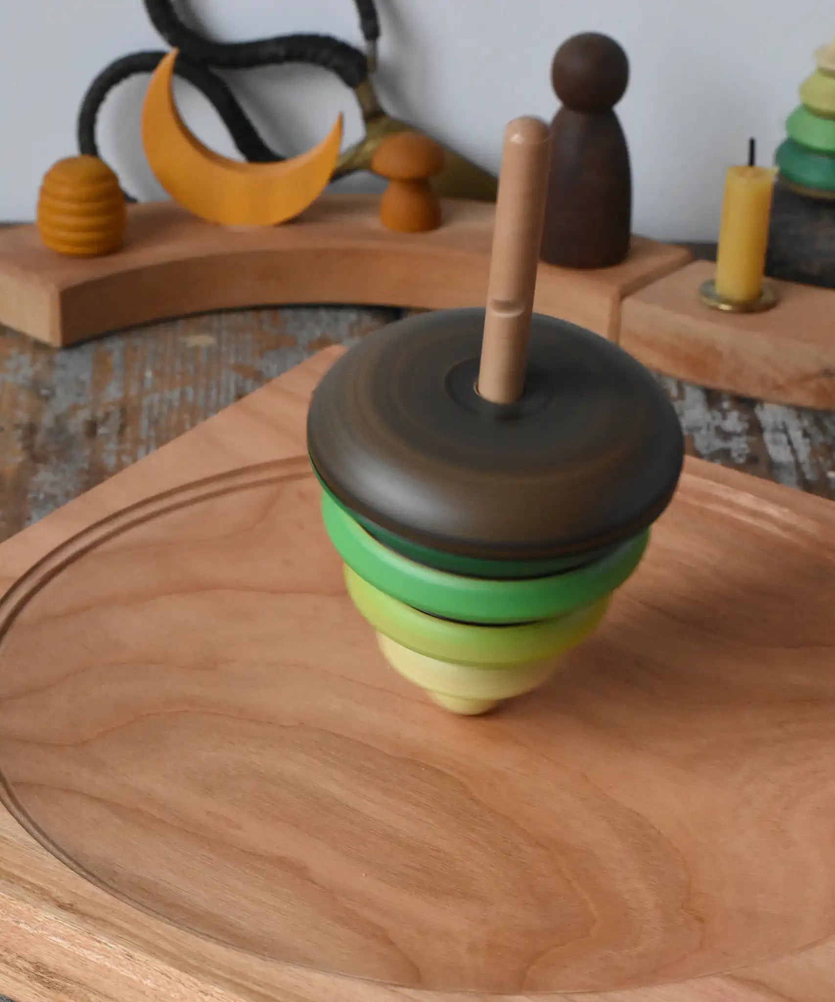 Mader pull-string tree spinning top spinning on a cherry wood spinning plate in the Babipur playroom.