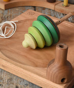 Mader pull-string tree spinning top placed on a cherry wood spinning plate in the Babipur playroom.