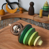 Mader pull-string tree spinning top placed on a cherry wood spinning plate in the Babipur playroom.