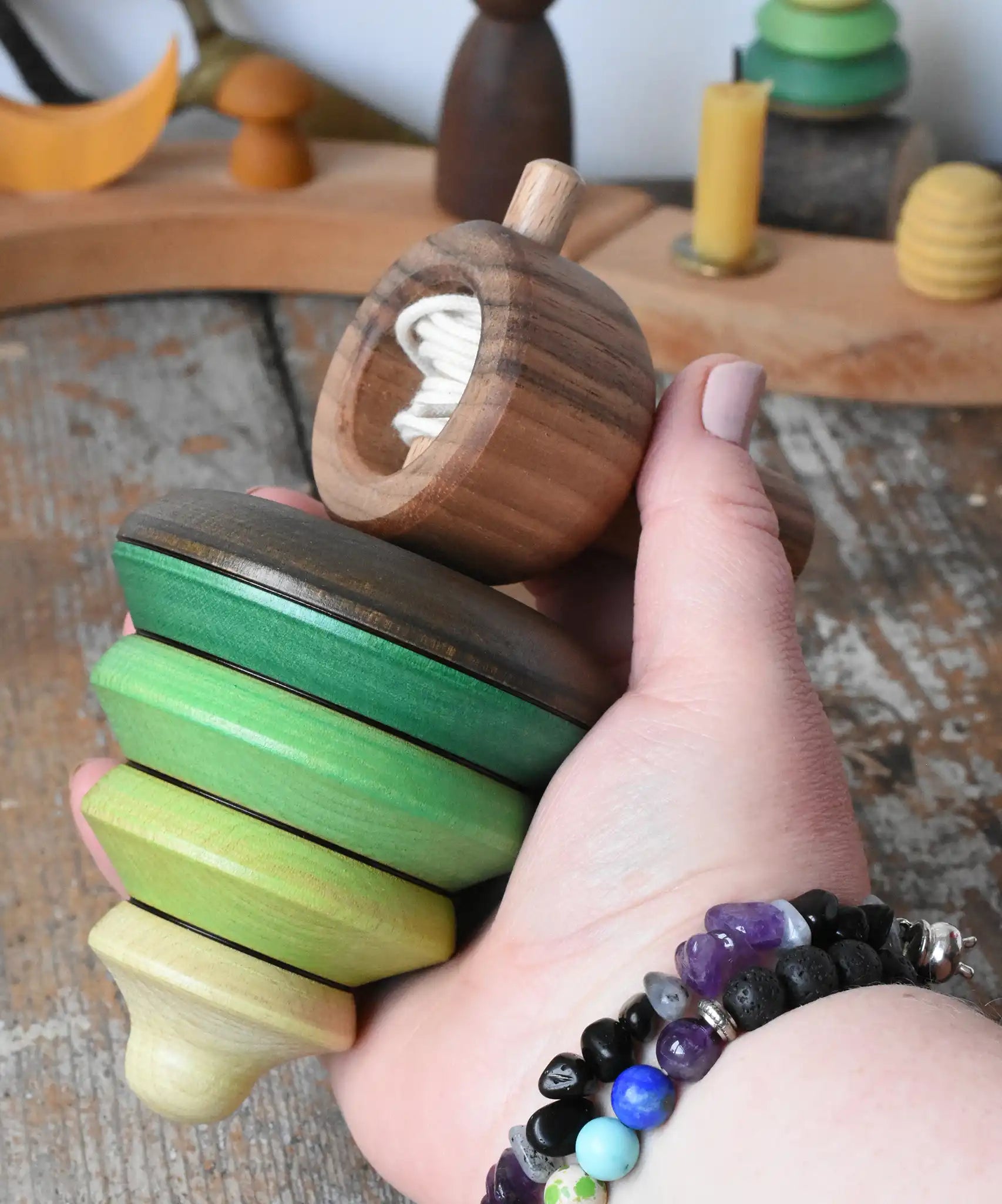 Mader pull-string tree spinning top in an adult's hand in the Babipur playroom.