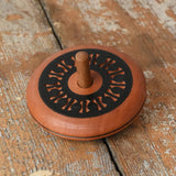 Mader Kreiselmanufaktur leporello wooden spinning top placed on a wooden desk in the Babipur playroom.