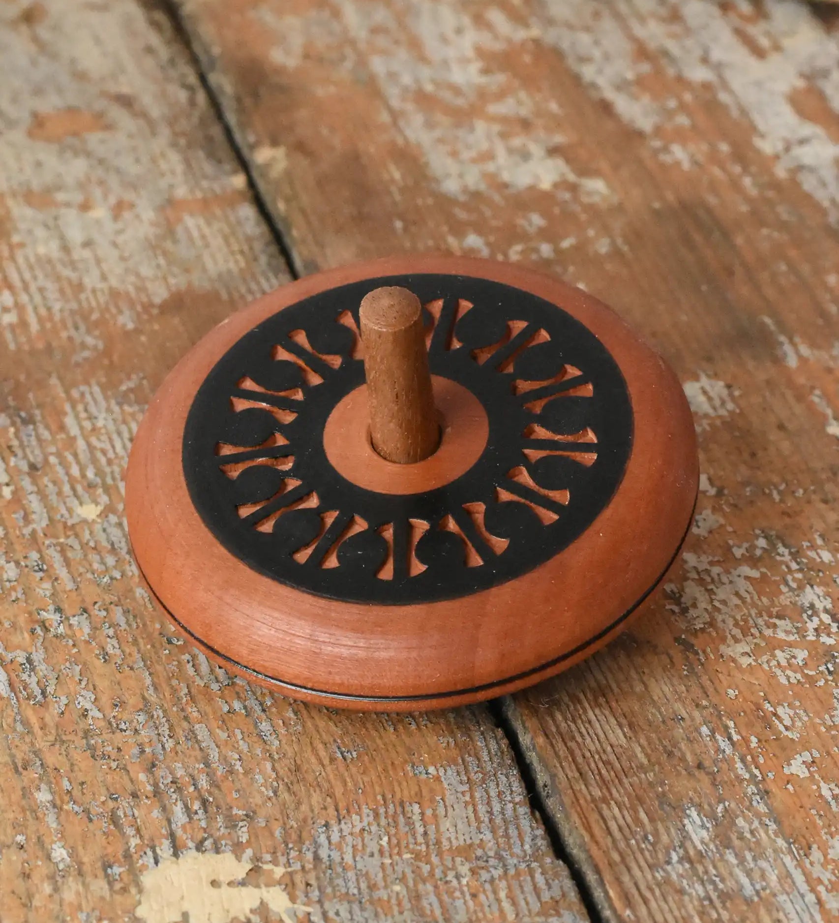 Mader Kreiselmanufaktur leporello wooden spinning top placed on a wooden desk in the Babipur playroom.