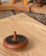 Mader Kreiselmanufaktur leporello wooden spinning top spinning on an ash spinning plate in the Babipur playroom.