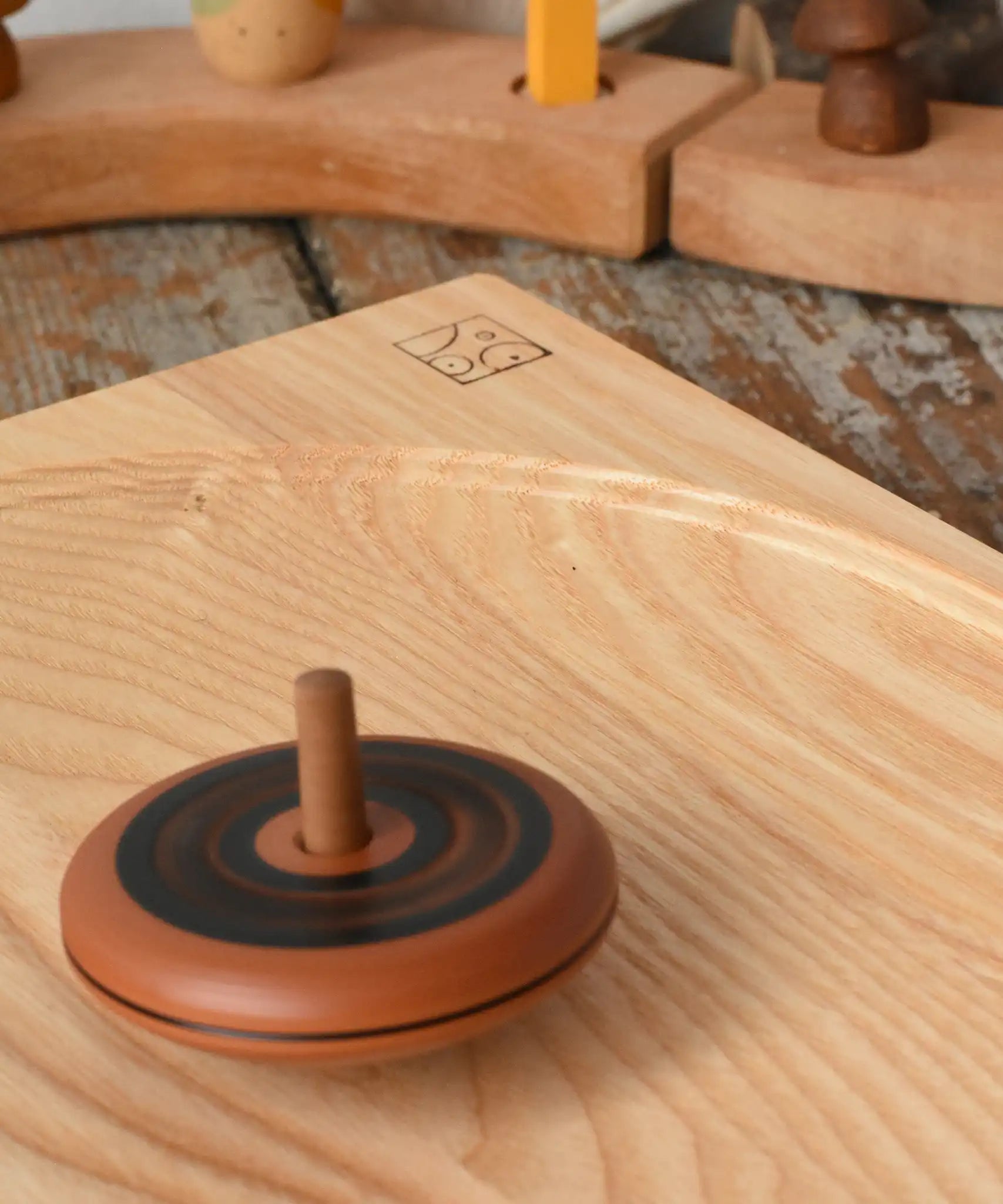 Mader Kreiselmanufaktur leporello wooden spinning top spinning on an ash spinning plate in the Babipur playroom.