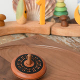 Mader Kreiselmanufaktur leporello wooden spinning top placed on a walnut spinning plate in the Babipur playroom.