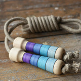 Mader Kreiselmanufaktur Skipping Rope with purple striped wooden handles placed on a wooden surface in the Babipur playroom. 